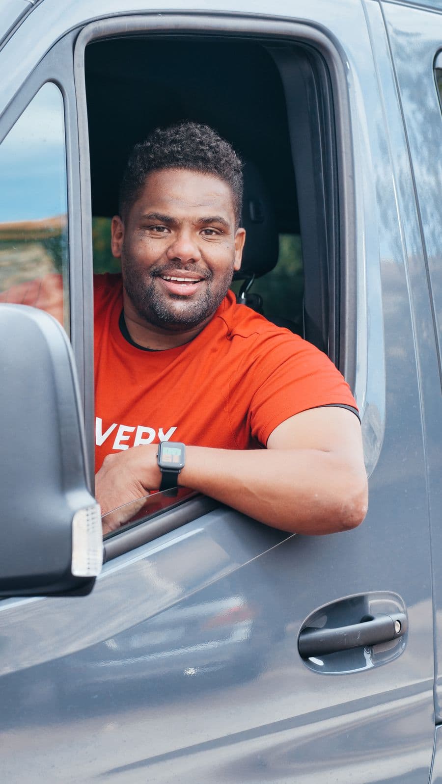 Chauffeur souriant au volant de sa camionnette professionnelle